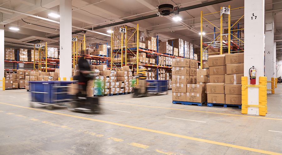 Interior view of our spacious warehouse with organized shelves and stacked boxes