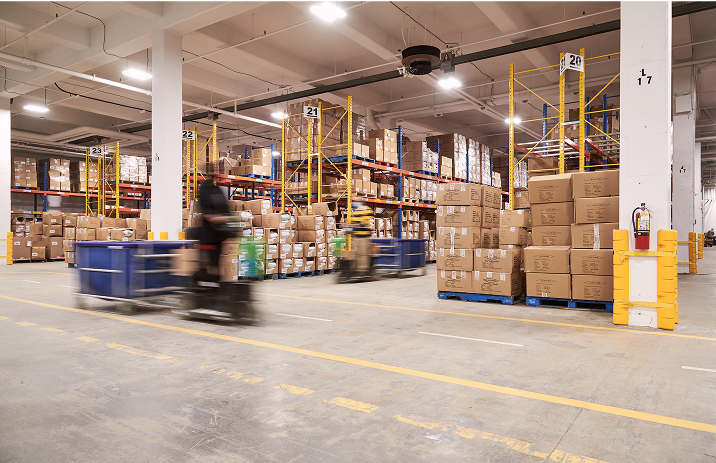 Interior view of our spacious warehouse with organized shelves and stacked boxes