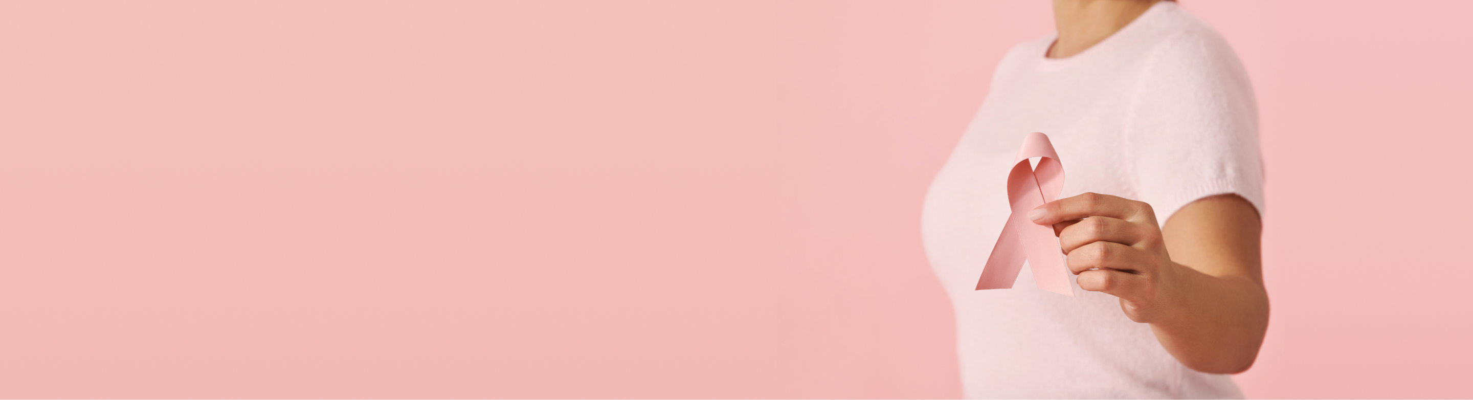Model holding a pink ribbon symbol of breast cancer awareness