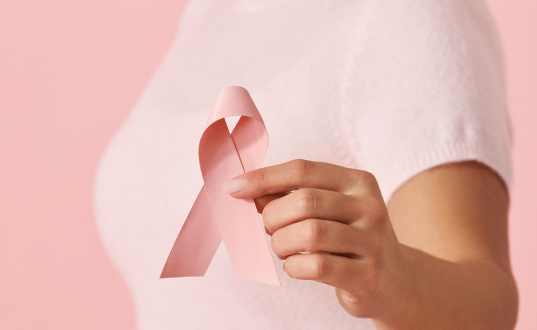 Model holding a pink ribbon symbol of breast cancer awareness