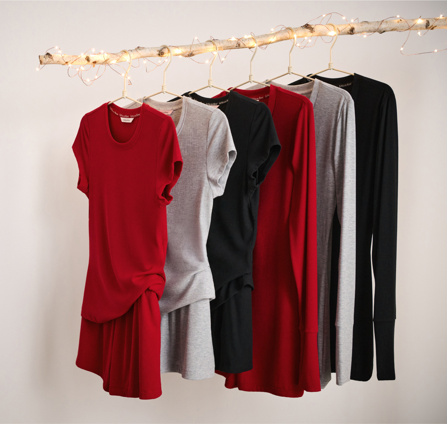 Ribbed modal pajamas in red, grey, and black hanging on a wooden rack.