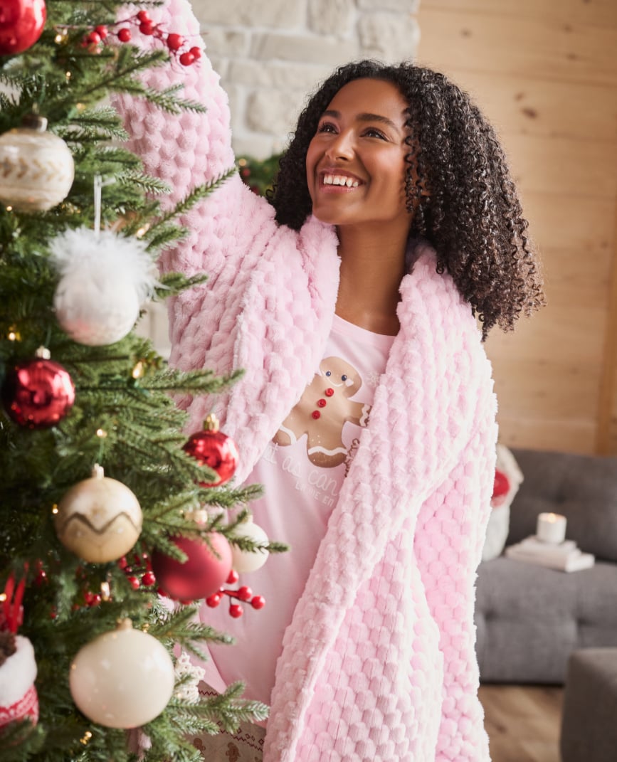 Model back view in black lace bodysuit with open back and satin bow.