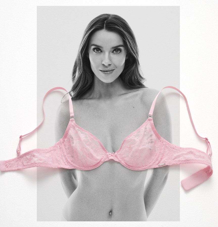 A pink lace bra laid on a black-and-white photo of a model