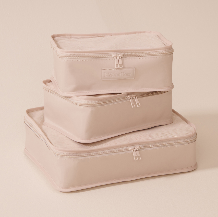 Set of three beige packing cubes with zippers, stacked by size, labeled La Vie en Rose.