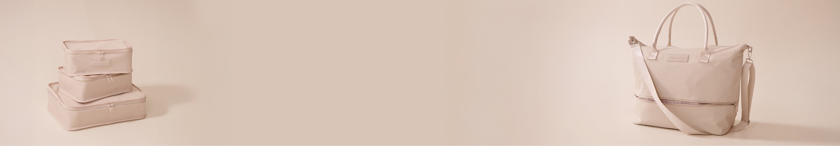 Seven beige travel accessories, including bags, pouches, and cases, placed on a table