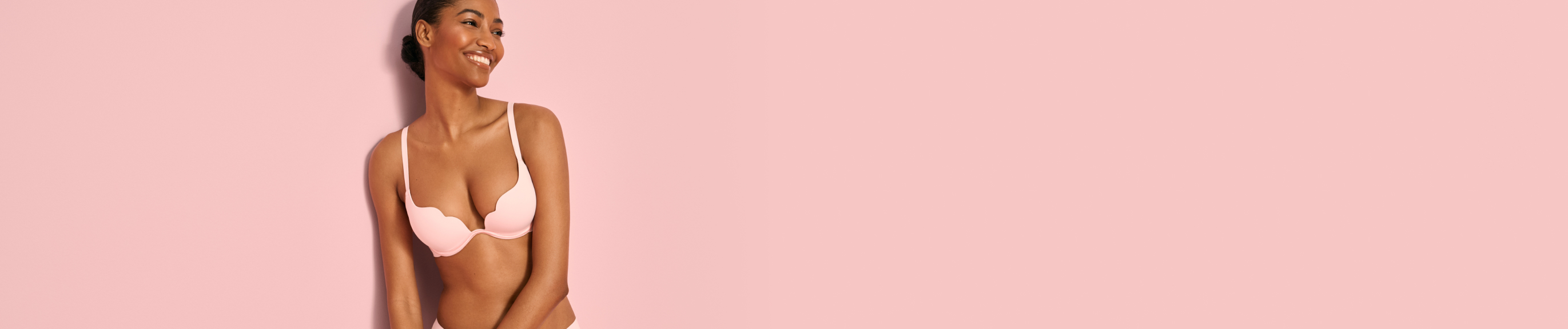 Model wearing a pale pink push-up scalloped bra