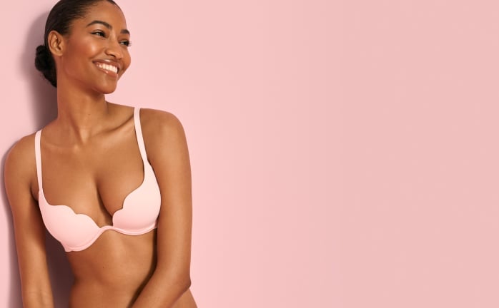 Model wearing a pale pink push-up scalloped bra