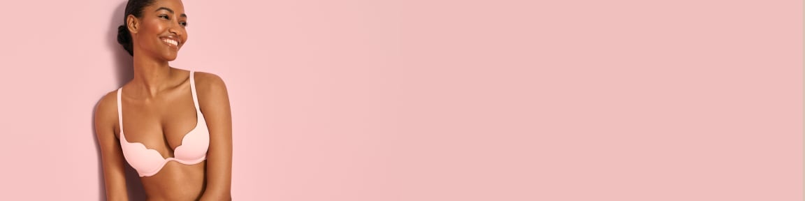 Model wearing a pale pink push-up scalloped bra