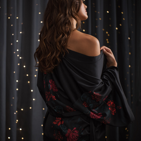 Model wearing a black satin kimono with red roses from the 40th anniversary collection.