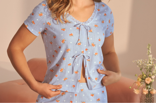 Model wearing blue pajamas with peach patterns