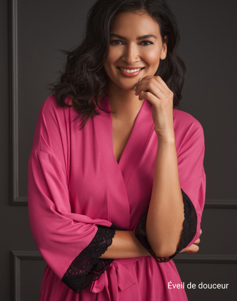 Mannequin de dos portant un body rose texturé avec un grand nœud à la taille et un dos ouvert.